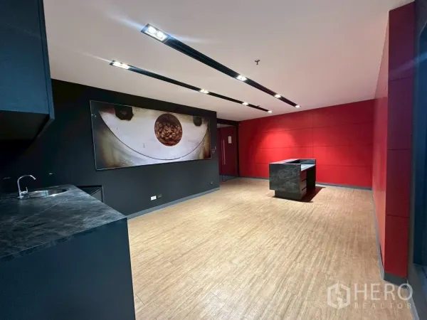 Office Space for rent - Lobby view showing a reception counter, kitchenette corner and bold red paneled walls.