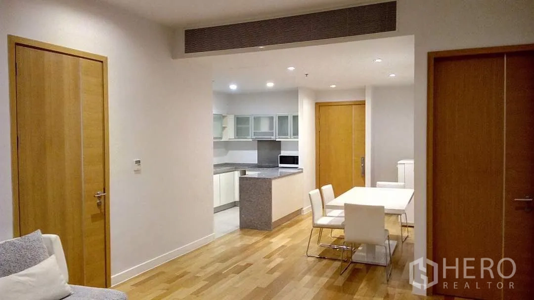 คอนโด ให้เช่าหรือขายในKhlong Toei, Bangkok - แปลนเปิดโล่ง พื้นไม้โทนอ่อน ชุดทานอาหาร และครัวตู้กระจกในคอนโดสมัยใหม่