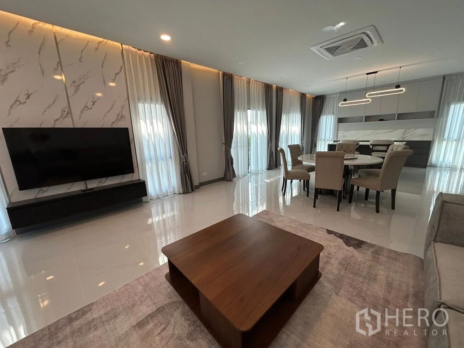独栋房屋 for rent in Bang Phli, Samut Prakan - 明亮客餐厅，电视背景墙、落地窗以及亮面地砖。