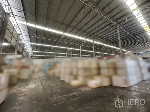 工厂 出租 - 带采光带的金属屋顶与钢柱，覆盖超大厂房地面与储存区域。