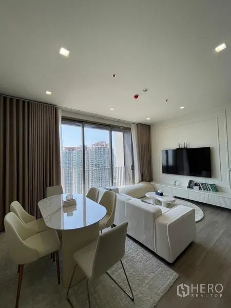 Condominium for rent in Bang Kho Laem, Bangkok - Living room with sofa, dining table, and balcony-height glazing.