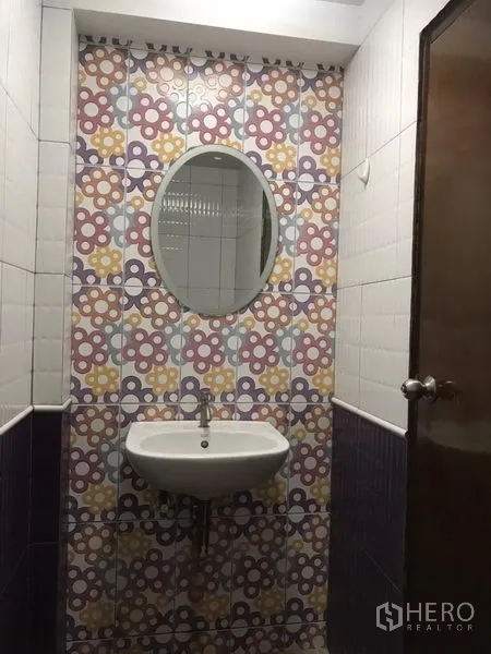零售空间 出租在Khlong Toei, Bangkok - 紧凑洗手间，彩色花纹瓷砖、椭圆镜与挂墙式洗手盆。