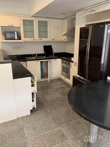 ทาวน์เฮาส์ ให้เช่าในKhlong Toei, Bangkok - ครัวรูปตัว U ตู้สีขาว เคาน์เตอร์หินสีดำ เตาอบ และตู้เย็นขนาดใหญ่