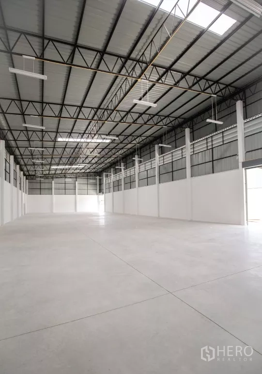 Factory for rent or sale in Bang Len, Nakhon Pathom - Large clear-span warehouse with ventilation panels and smooth concrete flooring.