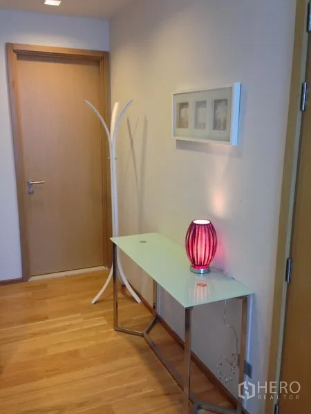 คอนโด ให้เช่าในWatthana, Bangkok - โถงทางเข้าพร้อมโต๊ะคอนโซลเพรียวบาง โคมไฟสีแดง และประตูไม้