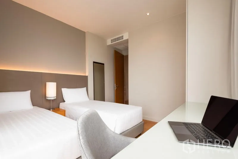 Condominium for rent in Bang Kho Laem, Bangkok - Twin-bed room with study desk, soft lighting and wood floors.