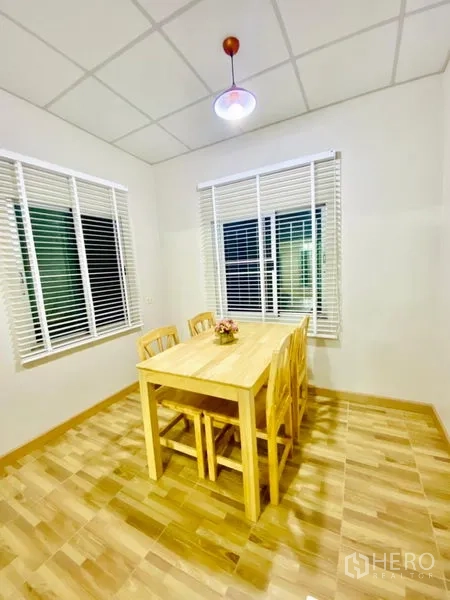 联排别墅 出租在Prawet, Bangkok - 转角餐区，吊灯与两侧采光窗。