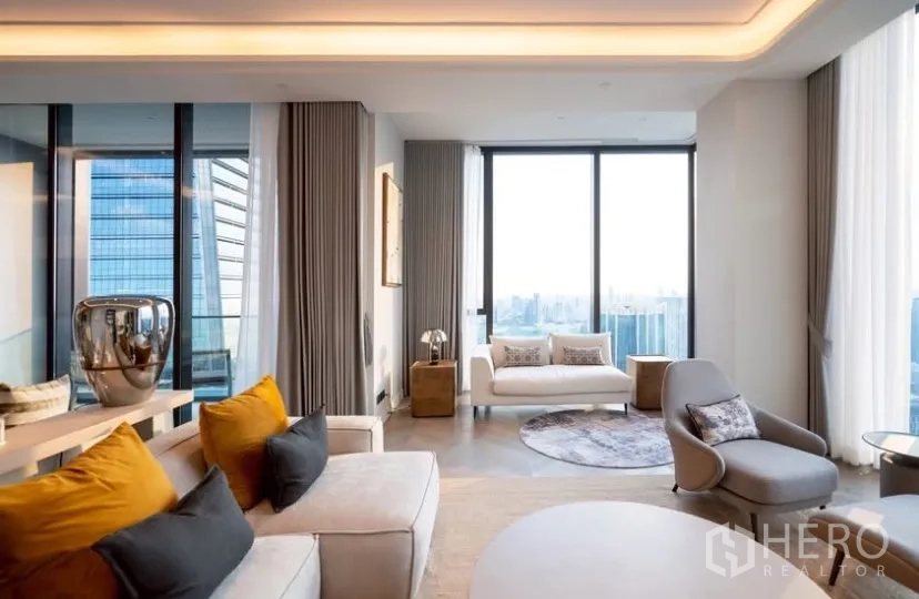 公寓 出租或出售在Pathum Wan, Bangkok - 转角客厅，弧形座椅、灯槽天花与环幕落地窗。