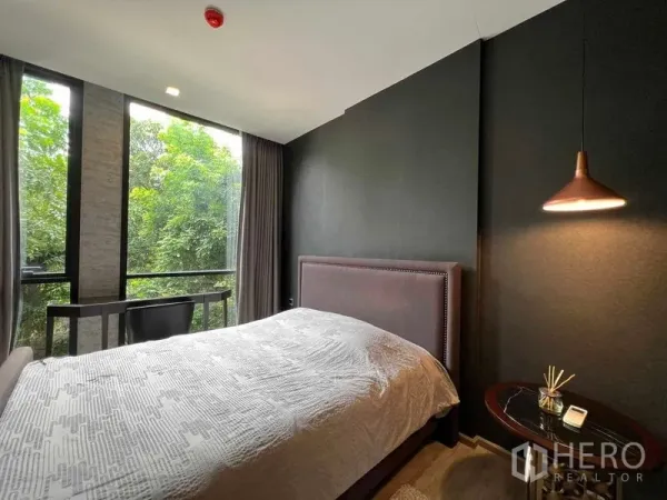 คอนโด ให้เช่าในWatthana, Bangkok - ห้องนอนหลักพร้อมหน้าต่างบานใหญ่ โต๊ะข้างเตียง และวิวสวน