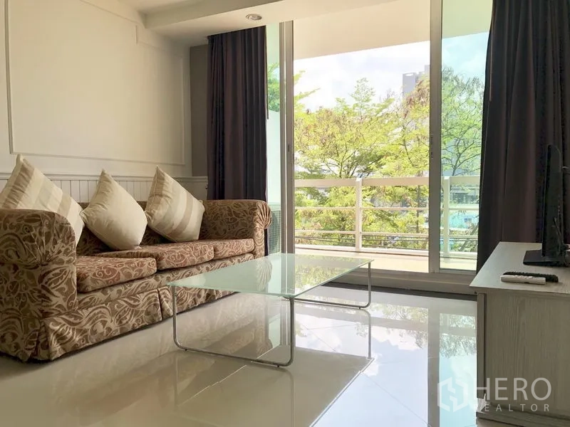 คอนโด ให้เช่าในKhlong Toei, Bangkok - ห้องนั่งเล่นเชื่อมระเบียงด้วยประตูกระจกบานเลื่อน มุมมองต้นไม้ร่มรื่น