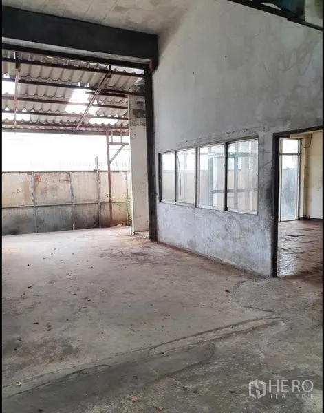 Warehouse for rent in Phra Samut Chedi, Samut Prakan - Covered loading area beside office windows and a large entry opening.