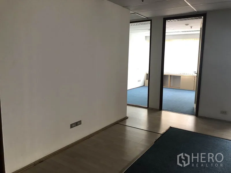 办公空间 出租在Watthana, Bangkok - 室内走廊，木地板与通往蓝色地毯办公室的门洞