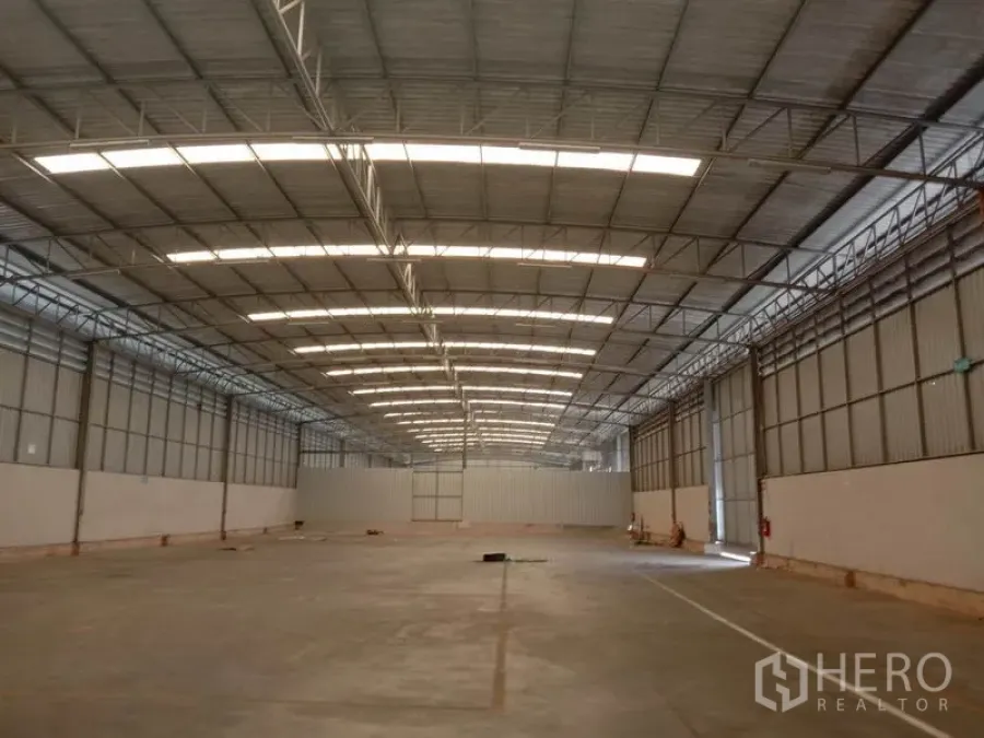 货栈 出租在Lat Krabang, Bangkok - 空置仓库内部，高钢桁架屋顶、采光带与平整的混凝土地面。