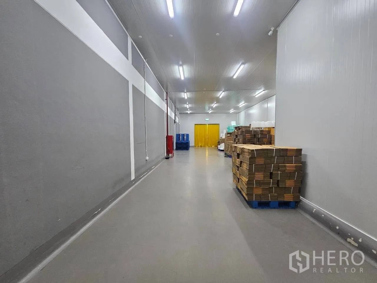 工厂 for rent in Mueang Samut Sakhon, Samut Sakhon - 室内长走道，灰色墙面、托盘与明亮灯带。