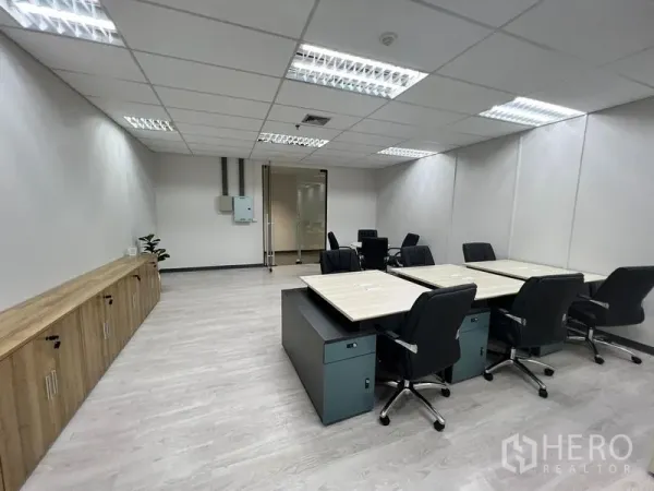 Office Space for rent in Sathon, Bangkok - Main workspace with clustered desks and swivel chairs, wall cabinets, and a glass entry door for a professional feel.