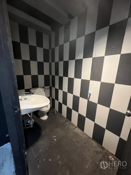 อาคารพาณิชย์ ให้เช่าในHuai Khwang, Bangkok - ห้องน้ำขนาดกะทัดรัด ผนังลายตารางขาวดำ พร้อมโถสุขภัณฑ์และอ่างล้างมือ