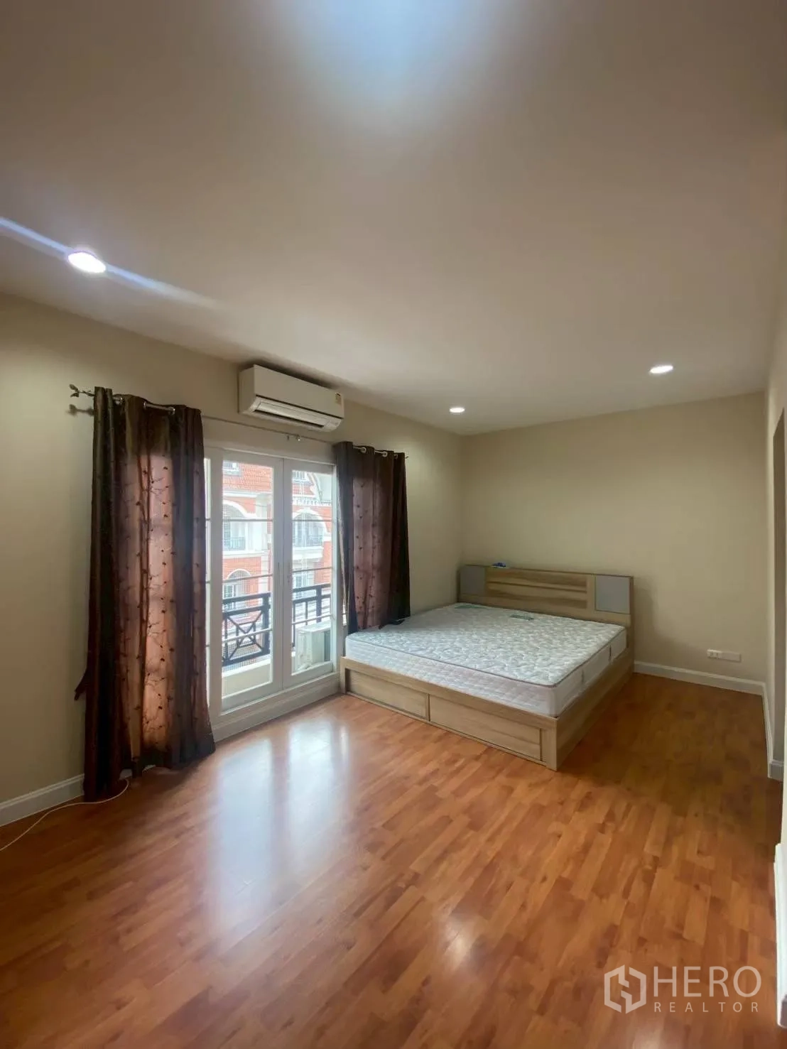 Townhouse for rent in Bang Kapi, Bangkok - Air-conditioned bedroom with balcony doors and curtains.