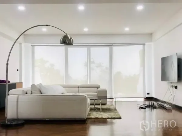 ทาวน์เฮาส์ ให้เช่าหรือขายในKhlong Toei, Bangkok - ห้องนั่งเล่นสว่าง โซฟาสีขาว โคมไฟโค้ง และหน้าต่างบานใหญ่เต็มผนัง