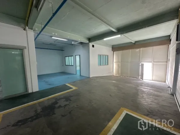 Warehouse for rent in Bang Na, Bangkok - Loading bay area with sliding doors, internal windows and blue epoxy floor room.