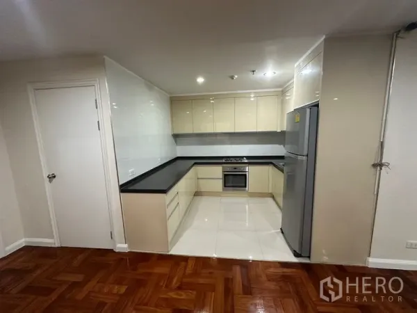 คอนโด ให้เช่าในWatthana, Bangkok - ครัวรูปตัว L ตู้บิวท์อิน เฉดเงางาม เคาน์เตอร์สีดำ เตาอบบิวท์อิน และตู้เย็นขนาดใหญ่