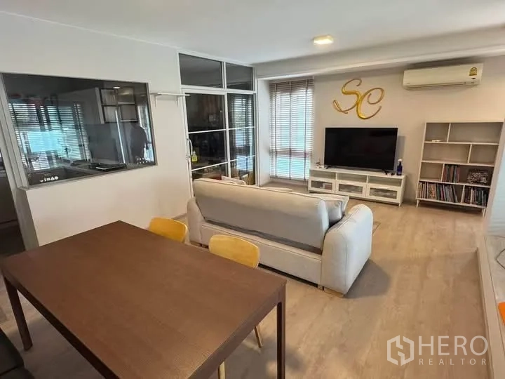 Semi-detached House for rent in Prawet, Bangkok - Open living and dining space with TV console and a glass-partitioned room.