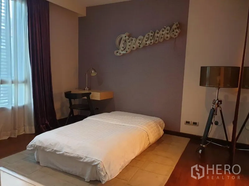 Detached House for sale in Watthana, Bangkok - Cozy bedroom with low platform bed, purple feature wall and study desk.