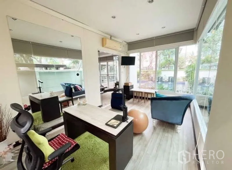 Detached House for rent in Bang Phli, Samut Prakan - Glass-walled home office with desk, lounge seating and views to the pool and garden.