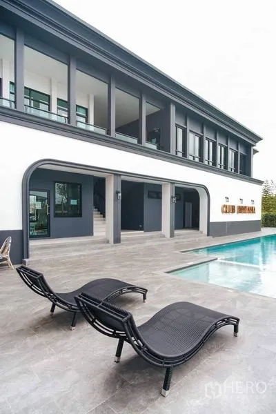 Detached House for rent in Bang Bo, Samut Prakan - Community clubhouse with swimming pool and poolside loungers.