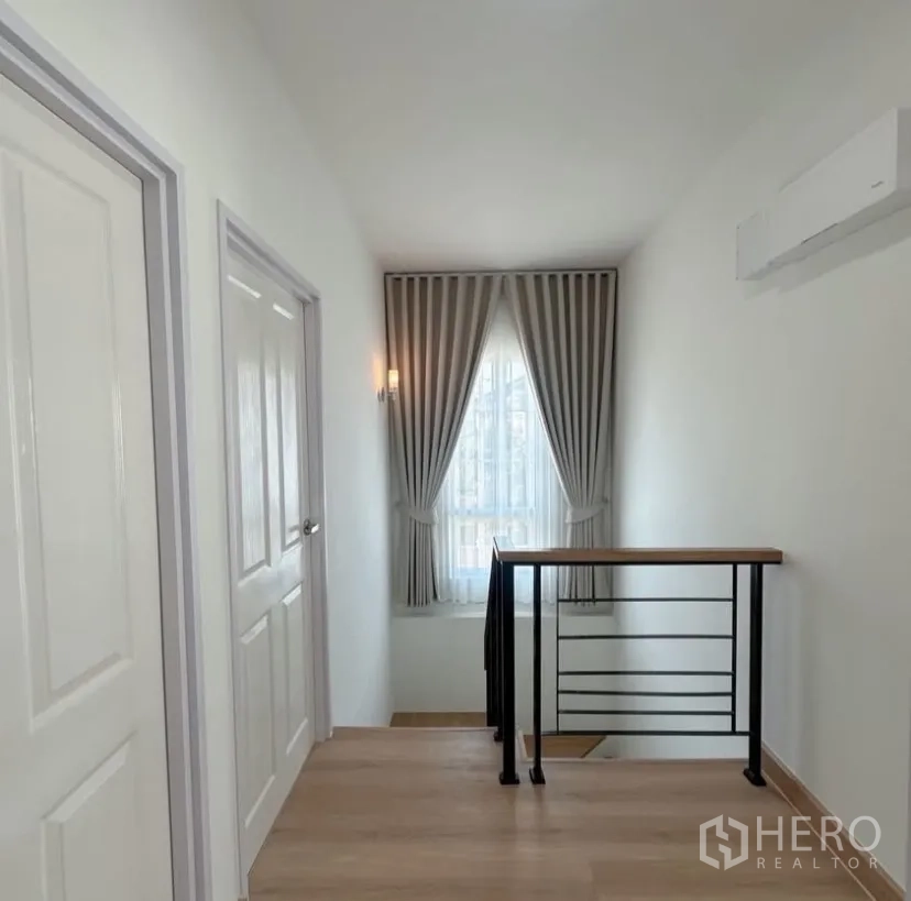 บ้าน ให้เช่าในMueang Samut Prakan, Samut Prakan - โถงบันได ราวเหล็กสีดำ หน้าต่างพร้อมผ้าม่าน และไฟติดผนัง