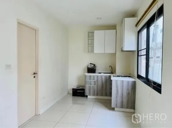 Townhouse for rent in Saphan Sung, Bangkok - Compact pantry kitchen with upper and lower cabinets, sink and a window for ventilation.