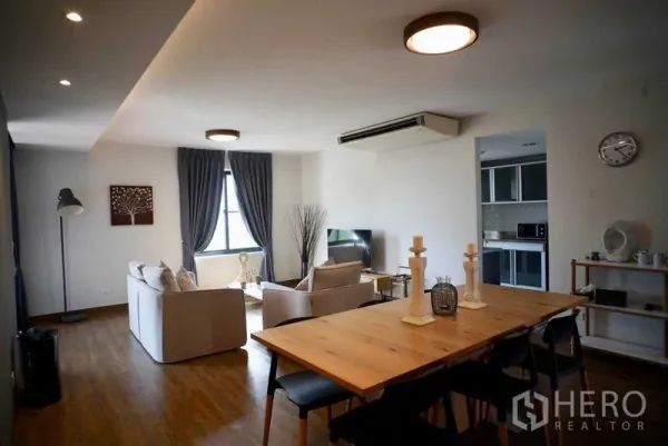 Condominium for rent in Watthana, Bangkok - Full view of living and dining room with kitchen entrance and wooden floors.