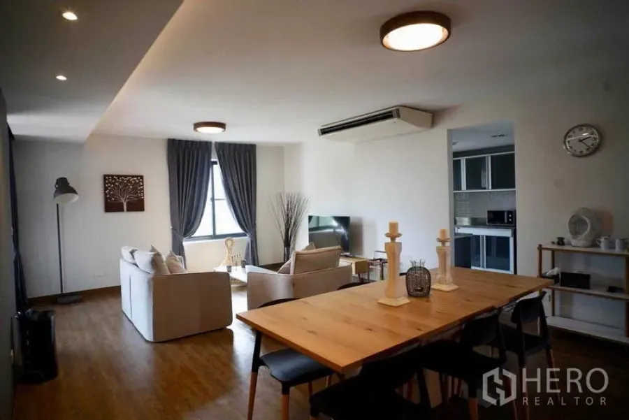 Condominium for rent in Watthana, Bangkok - Full view of living and dining room with kitchen entrance and wooden floors.