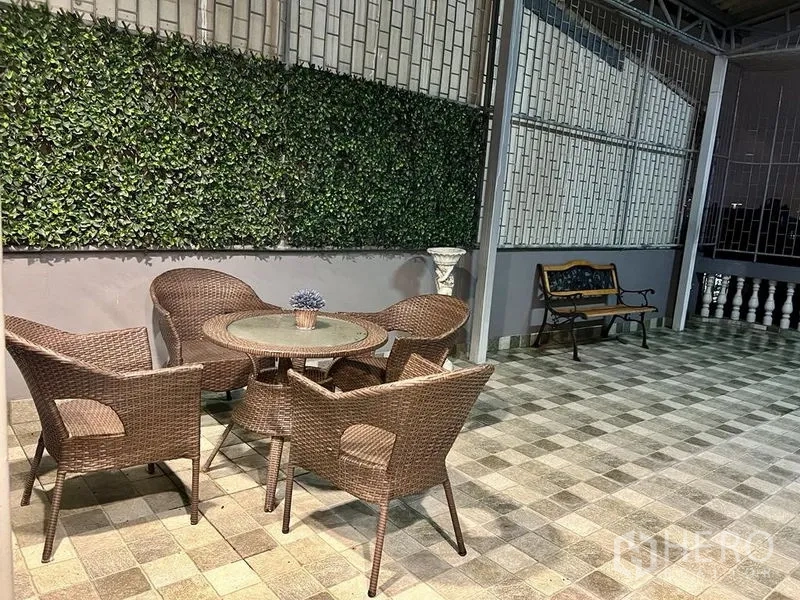 Shophouse for sale in Bang Kho Laem, Bangkok - Wide balcony terrace with rattan seating and a bench.