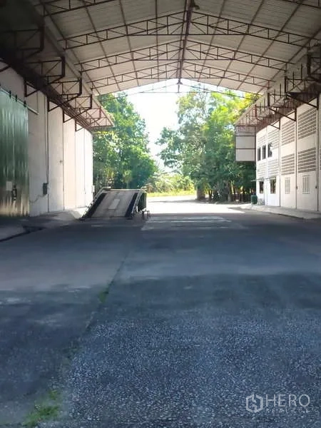 货栈 出租在Mueang Rayong, Rayong - 大型钢结构雨棚下的装卸区，设有卡车升降坡道。