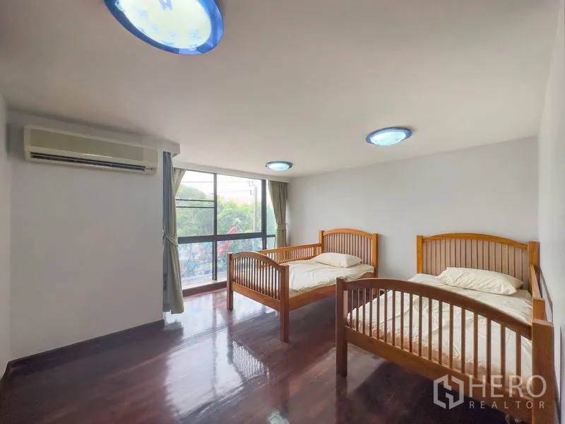 Condominium for sale in Samut Prakan - Guest bedroom with two single beds, air-conditioning and a large window.