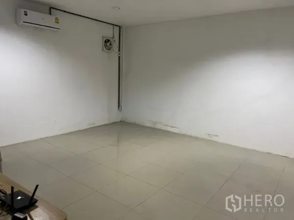 Warehouse for rent in Lat Krabang, Bangkok - Air-conditioned office room inside the warehouse with tiled floor, white walls, and ventilation fan.