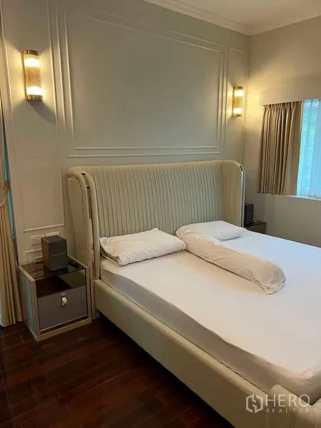 Detached House for sale in Bueng Kum, Bangkok - Cozy master bedroom with upholstered headboard, wall sconces, and window drapes.