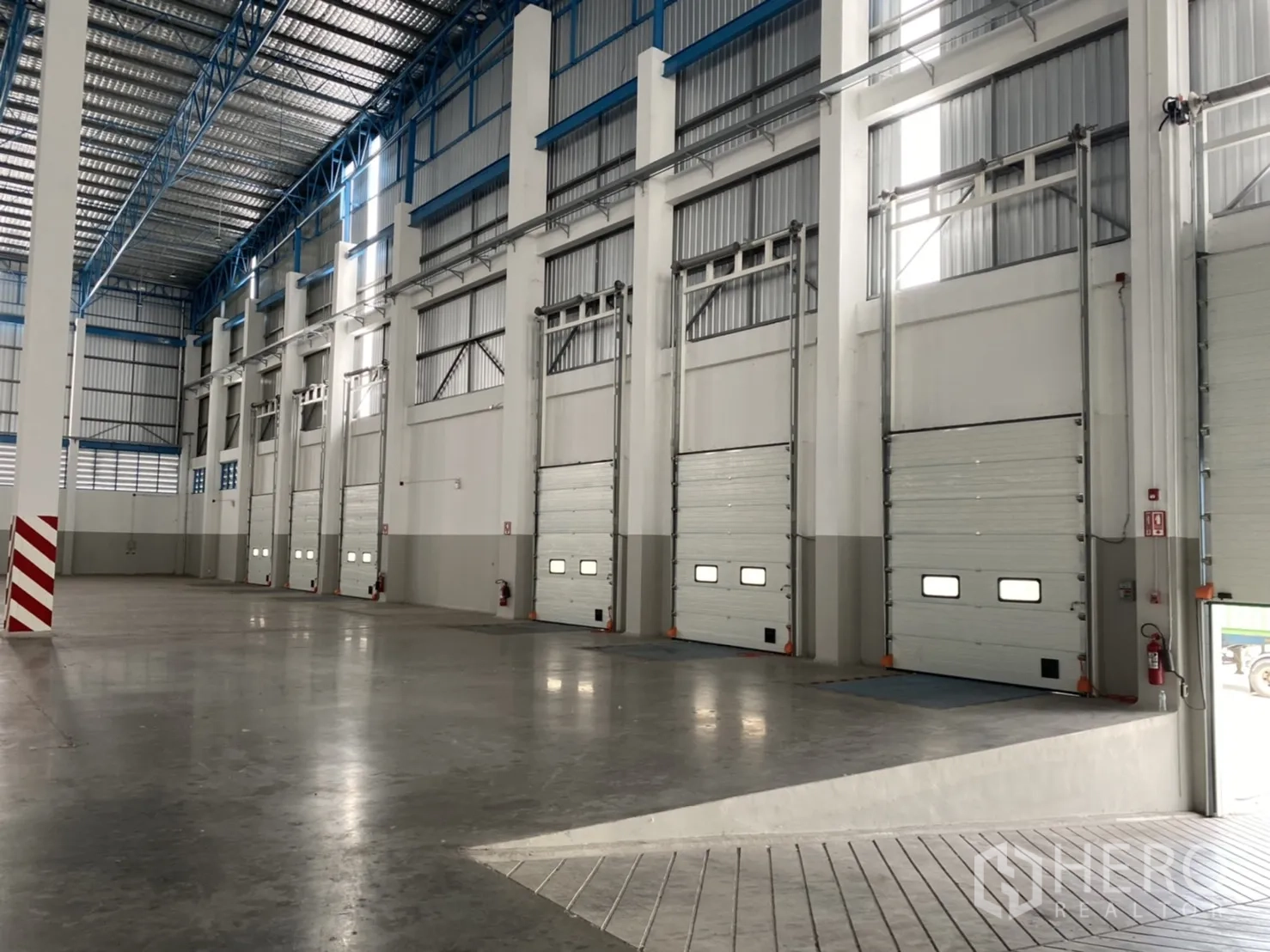 Warehouse for rent in Chachoengsao - Interior loading area with multiple insulated dock‑high doors and ramp access.