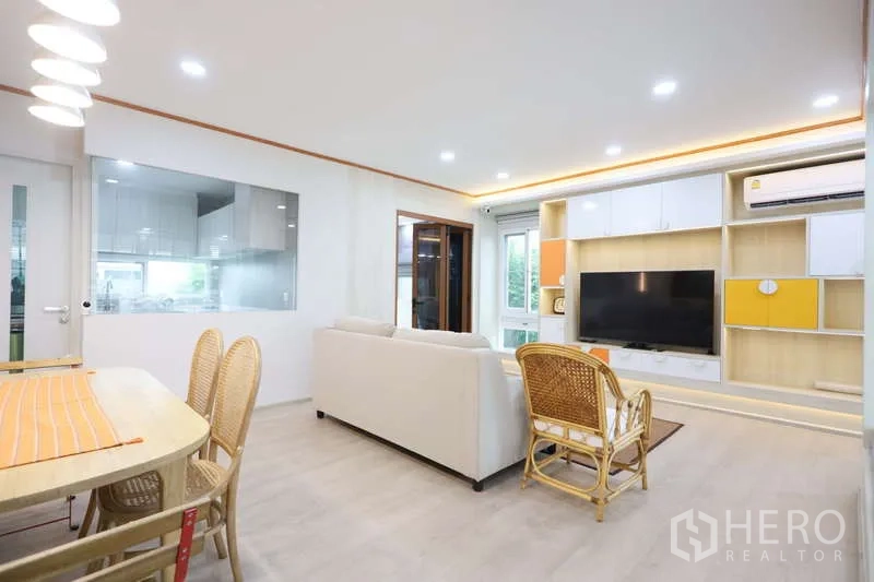 Detached House for rent or sale in Prawet, Bangkok - View of living–dining area toward the kitchen with glass partition and sliding door.