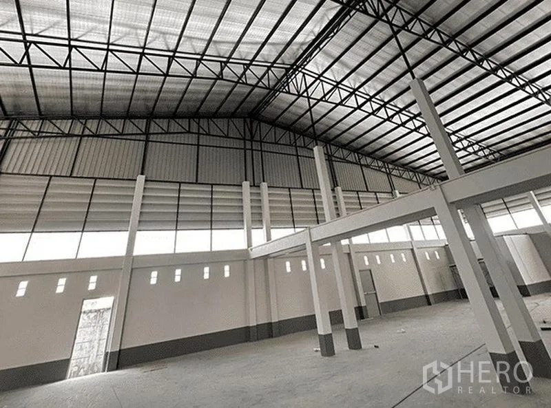 Warehouse for rent in Bang Pakong, Chachoengsao - Spacious warehouse interior featuring a high steel-truss roof, clerestory windows and smooth concrete floor.