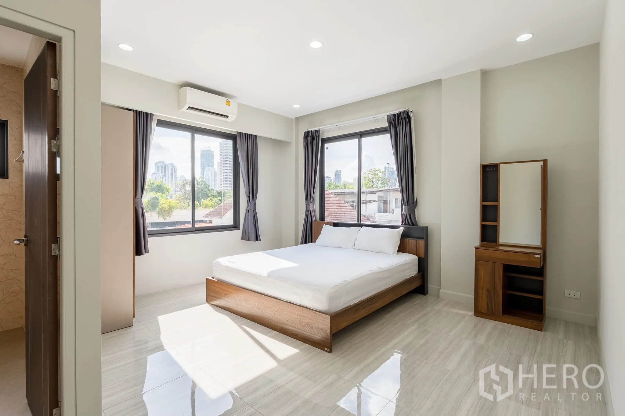 家庭办公室 for rent in Khlong Toei, Bangkok - 采光充足的卧室，双人床，大窗、空调与城市景观。