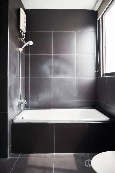 ทาวน์เฮาส์ ให้เช่าในKhlong Toei, Bangkok - ห้องน้ำกระเบื้องสีดำมีอ่างอาบน้ำและเครื่องทำน้ำอุ่น