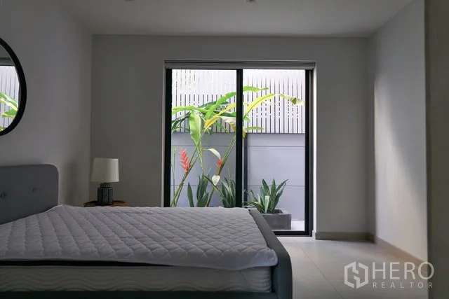 联排别墅 出租在Watthana, Bangkok - 花园景观卧室，推拉门直通种植槽。