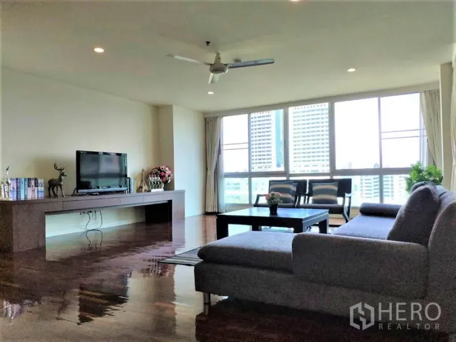 Condominium for rent in Bang Rak, Bangkok - Bright living area with sectional sofa, coffee table and wide windows offering city views.