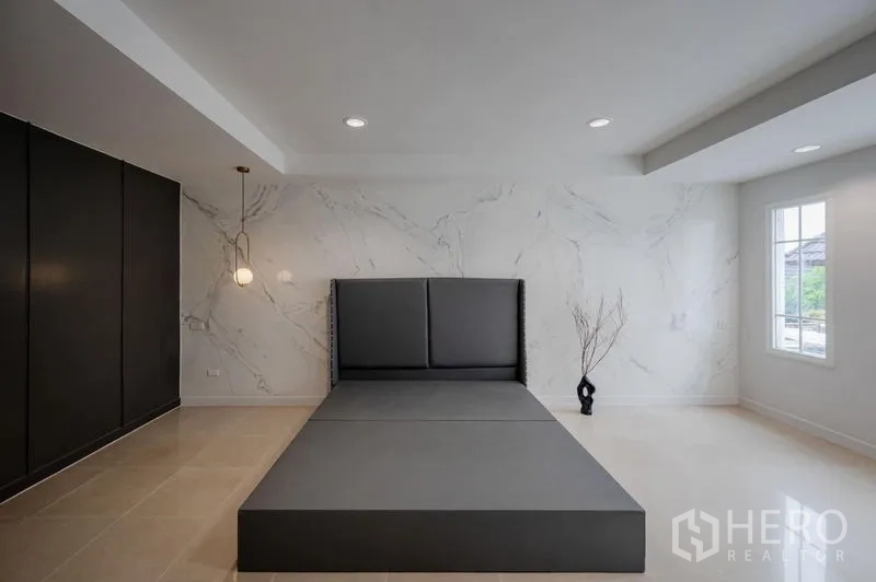 ทาวน์เฮาส์ ขาย - ห้องนอนกว้าง ผนังลายหินอ่อน เตียงแพลตฟอร์ม และตู้เสื้อผ้าบิวท์อินสีเข้ม