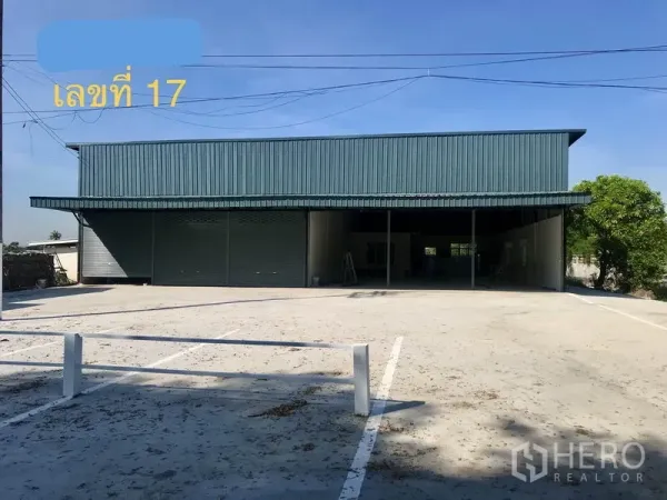 货栈 出租在Lam Luk Ka, Pathum Thani - 仓库正立面，金属外墙，宽阔混凝土前院与双卷帘门，位于Lam Luk Ka。