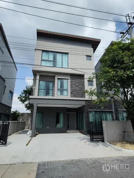 บ้าน ให้เช่าในSaphan Sung, Bangkok - ภายนอกบ้านเดี่ยวสไตล์โมเดิร์นสูงสามชั้น มีโรงจอดรถและระเบียง