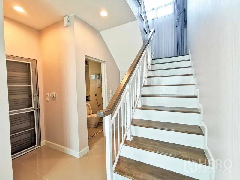 บ้าน ให้เช่าหรือขายในPrawet, Bangkok - บันไดโปร่ง พื้นไม้ ราวจับสีขาว พร้อมห้องน้ำชั้นล่าง