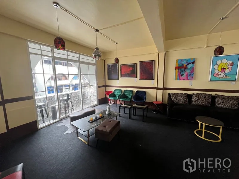 อาคารพาณิชย์ ให้เช่าในKhlong Toei, Bangkok - พื้นที่นั่งเล่นมีโซฟา เก้าอี้หลากสี และประตูกระจกบานเลื่อนไปยังระเบียง