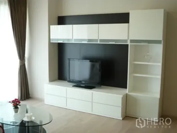 公寓 出租在Watthana, Bangkok - 现代客厅，白色电视柜与置物架，旁有大窗。